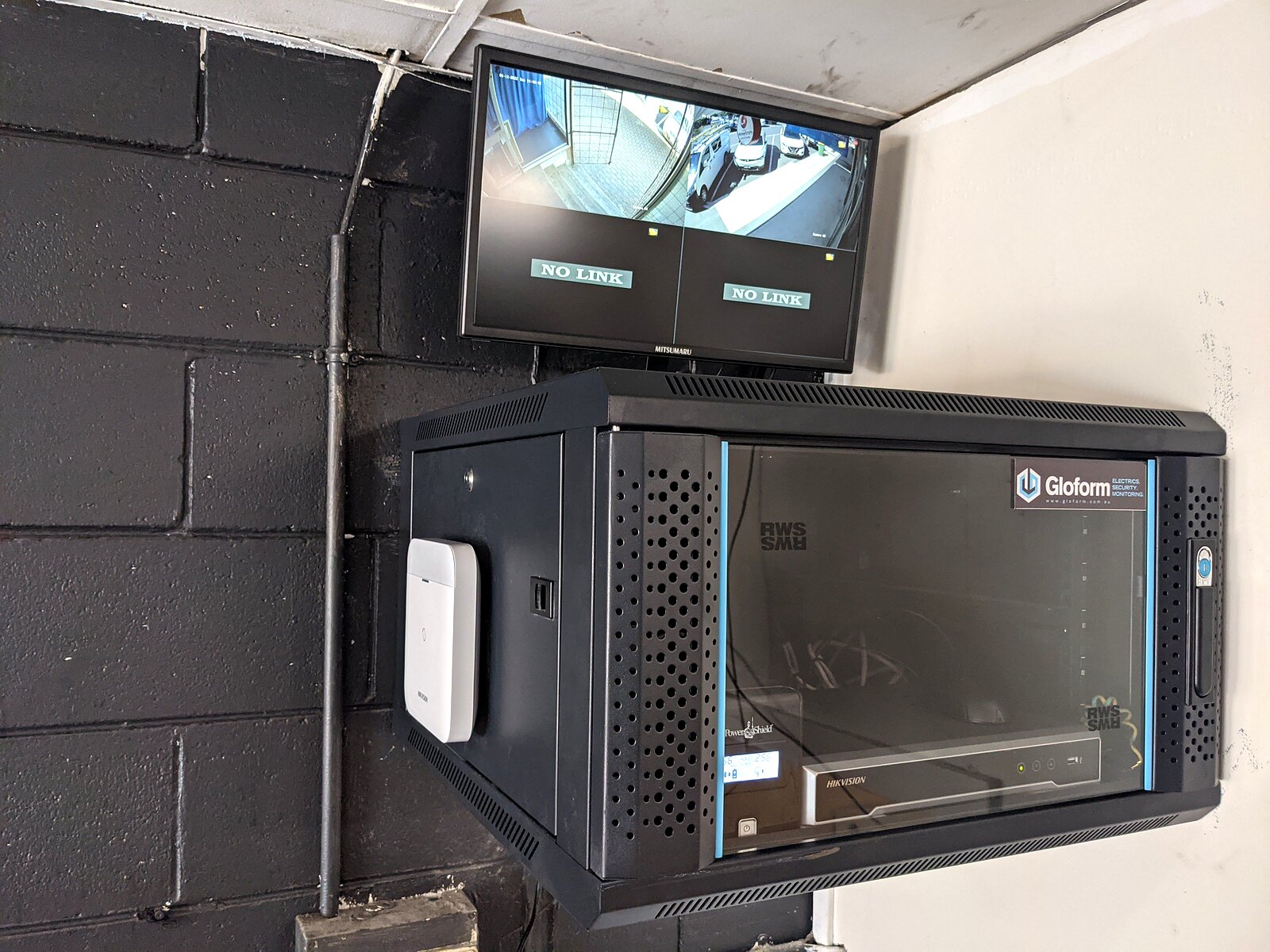 Wall-mounted CCTV cabinet with monitor showing camera feeds